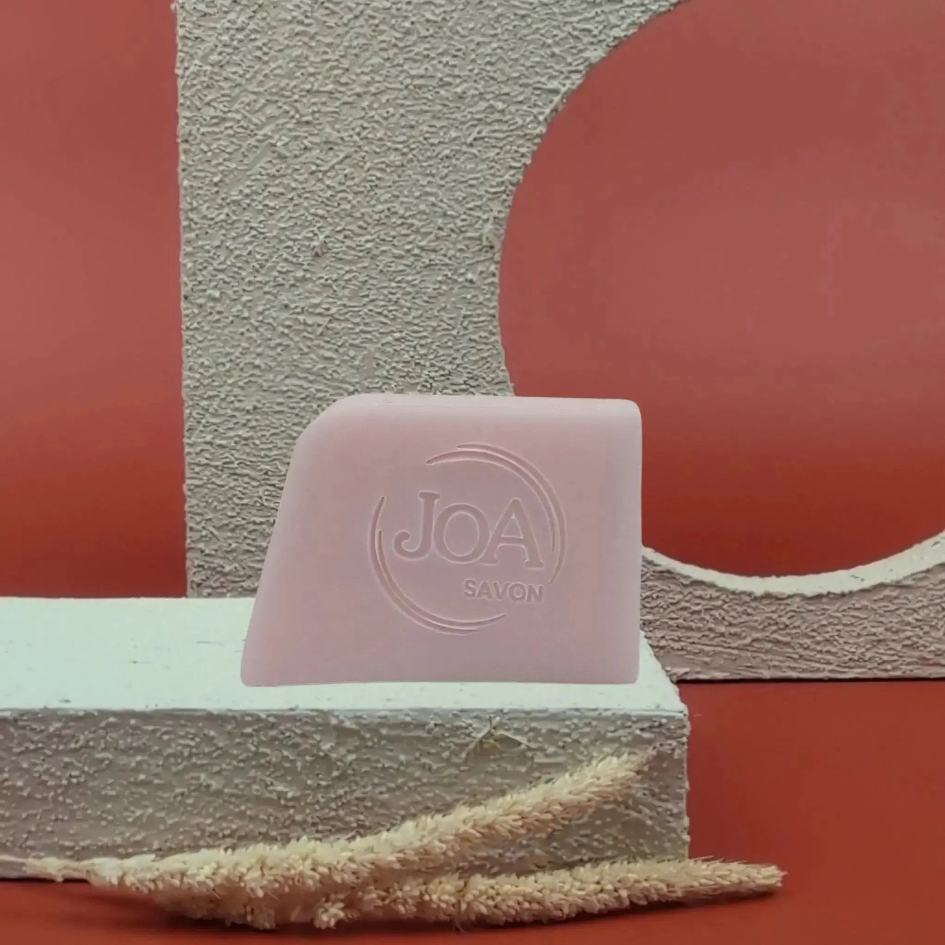 Savon Joa Rose musquée rose pâle sur fond rouge texturé