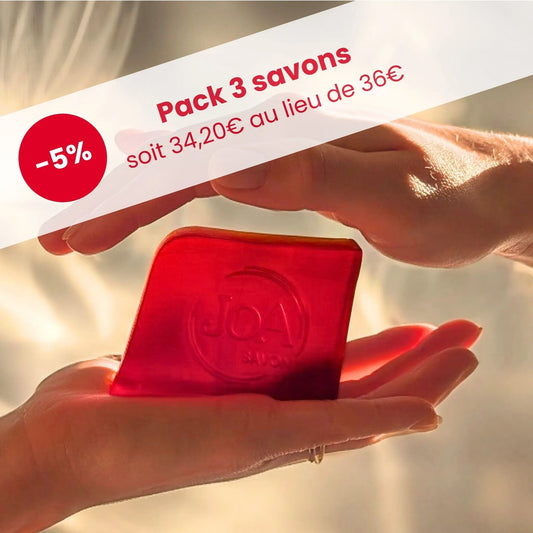 Visuel Joa Savon : Pack 3 savons en promotion (-5 %, 34,20 € au lieu de 36 €), savon rouge translucide tenu entre deux mains, lumière dorée.