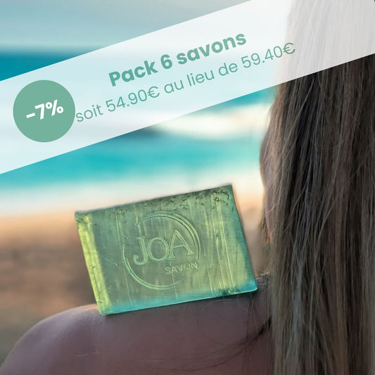 Visuel Joa Savon : Pack 6 savons en promotion (-7 %, 54.90€ au lieu de 59.40€), savon vert translucide posé sur l’épaule avec fond plage.