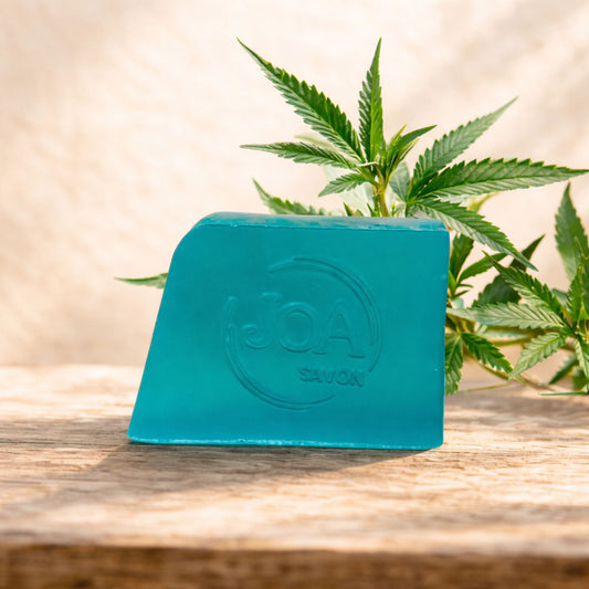 Savon Chanvre Joa Savon dans une ambiance naturelle avec feuilles de chanvre et bois