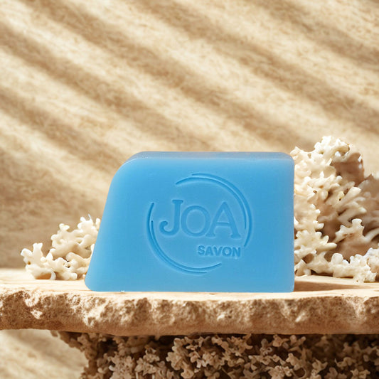 Savon Corail Sport Joa Savon dans une ambiance spa avec sable et éléments marins