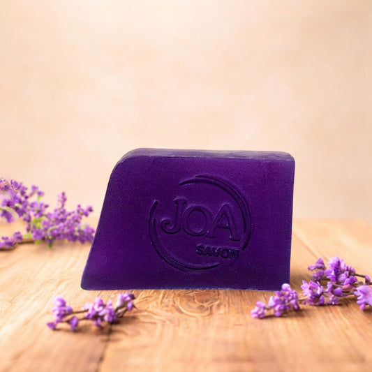 Savon Patchouli Joa Savon dans une ambiance naturelle et apaisante avec fleurs violettes