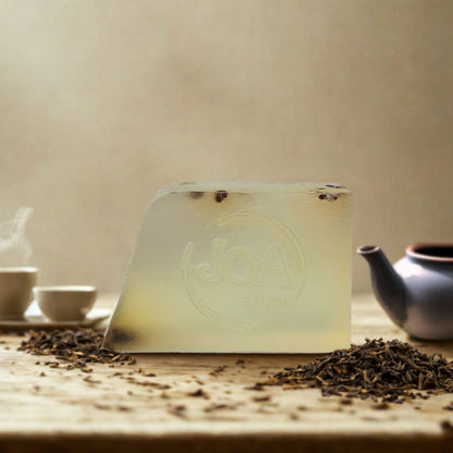 Savon Thé Vert Joa Savon dans une ambiance apaisante avec feuilles de thé et accessoires bien-être